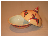 A Bali stoneware casserole pot, decorated with horses in a fun fair merry-go-round - third view.